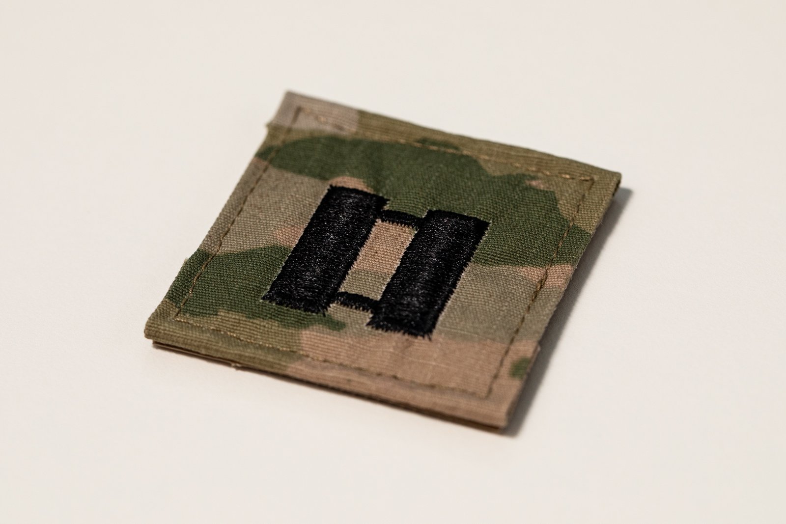 Close-up photograph of a U.S. Army captain’s rank patch showing the embroidered double-bar insignia.